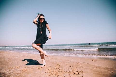 tattooed woman wearing sunblock at the beach