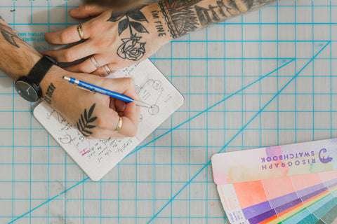 tattooed hands drawing