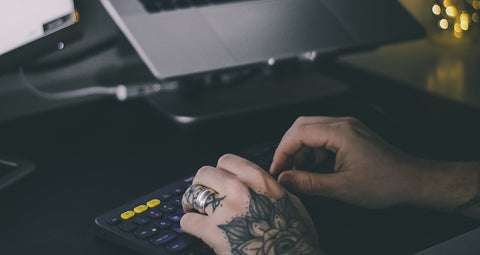 tattooed hand typing