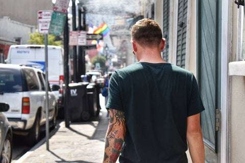 tattooed man walking down the street