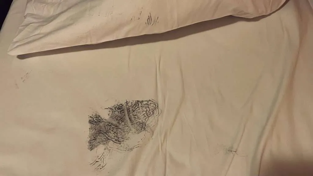 Tattoo ink stained bed sheets after blackout tattoo