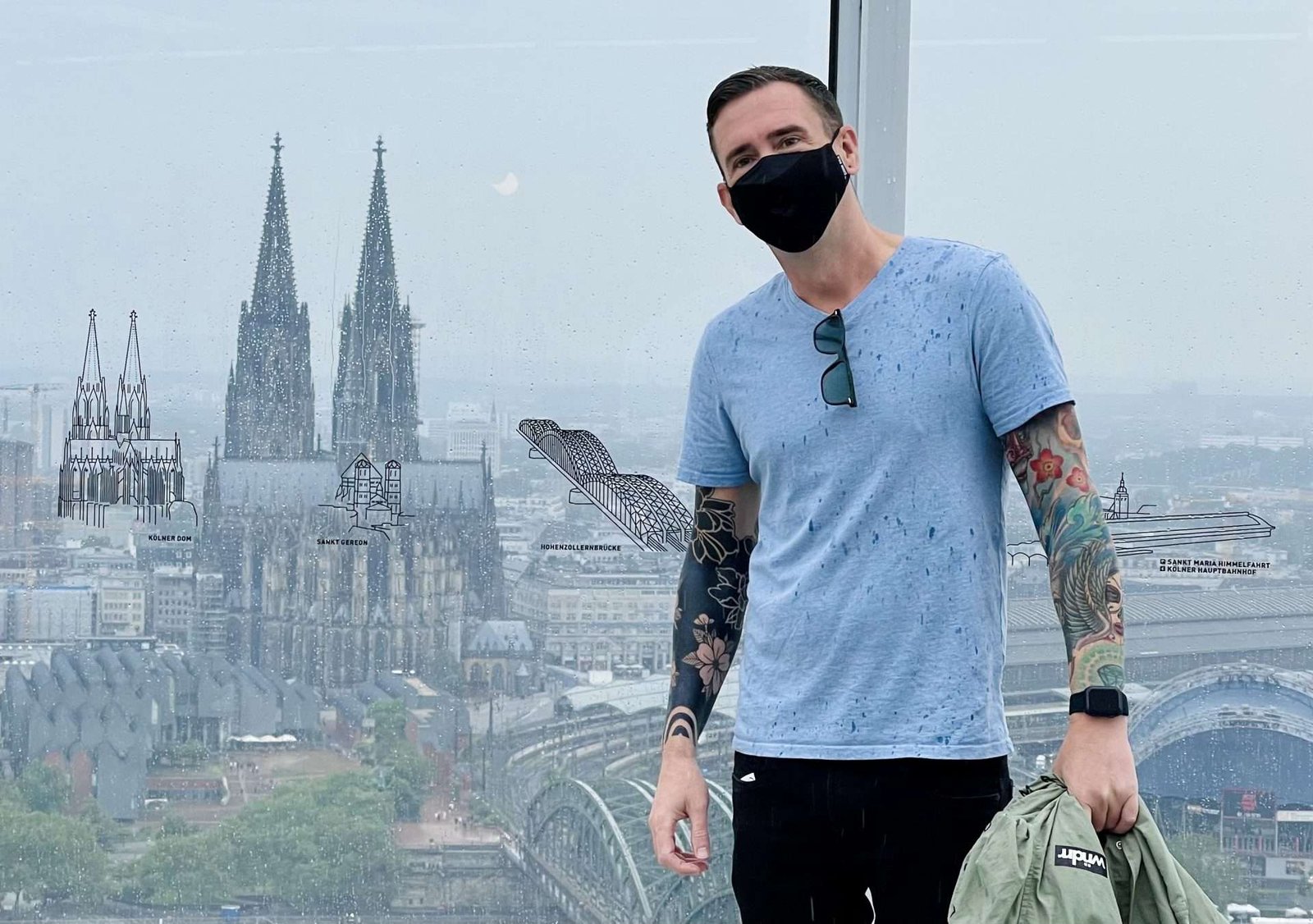 Kieran in Germany with negative space blackout tattoo sleeve and colored tattoo sleeve