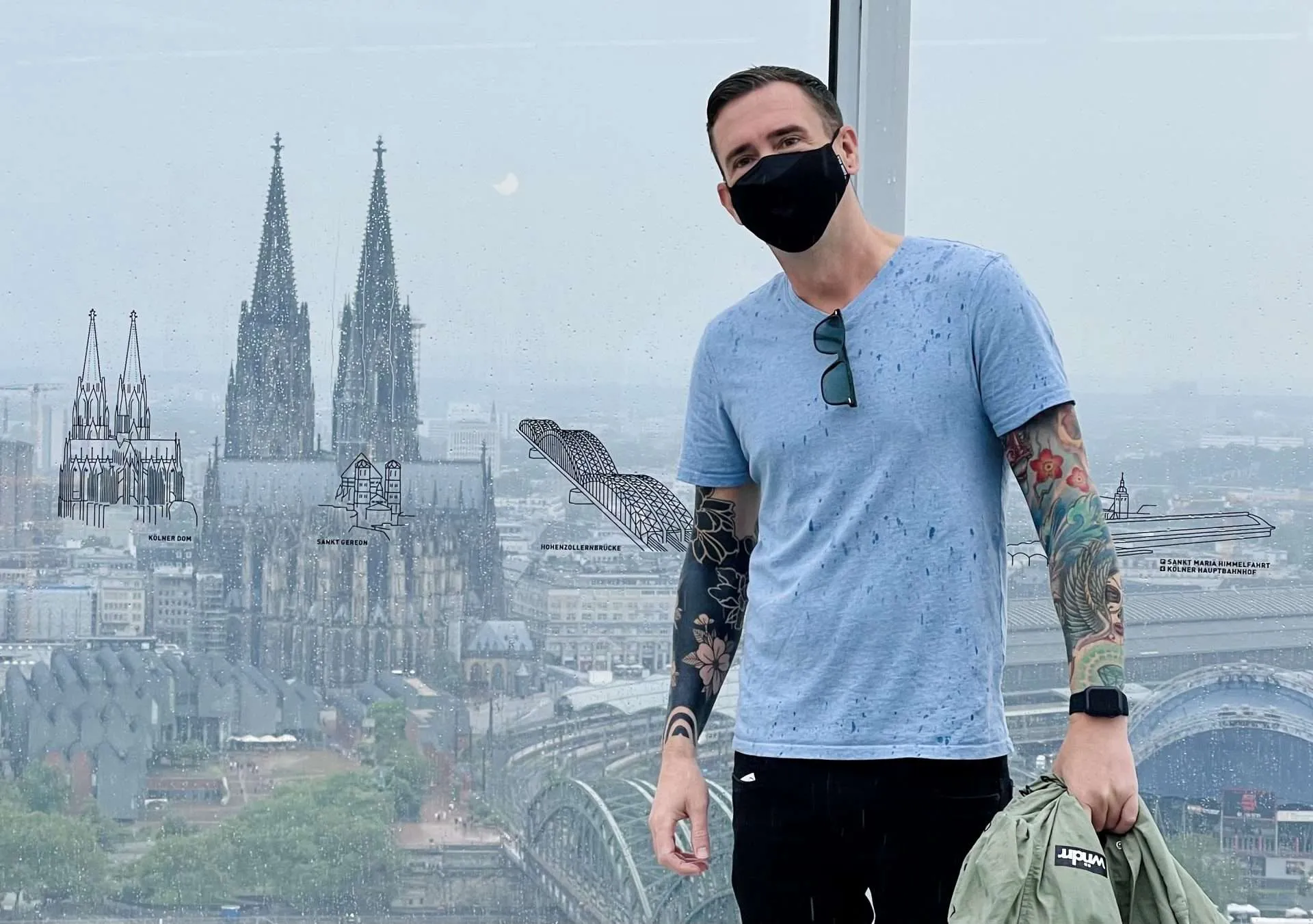 Kieran in Germany with negative space blackout tattoo sleeve and colored tattoo sleeve